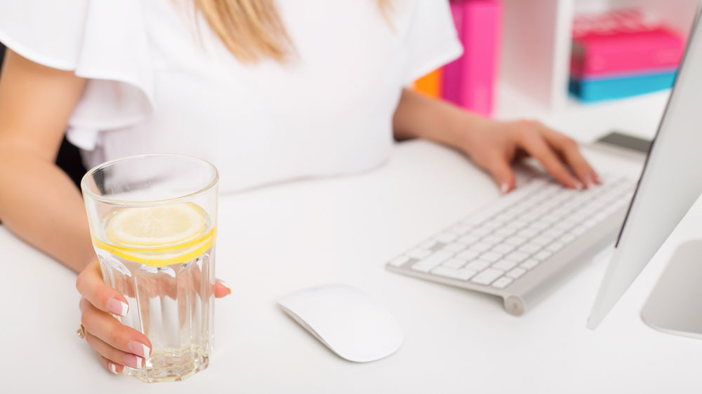 glass of cold water and lemon for a refreshing drink in the office